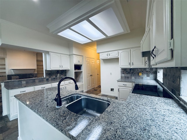 2147 Heather Green Dr, Houston, TX 77062 - kitchen featuring a peninsula, dark stone countertops, tasteful backsplash, white cabinetry, and stove