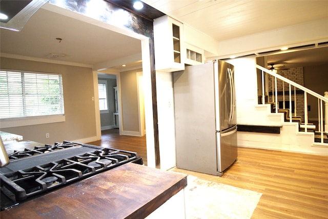 522 Oyster Creek Dr, Richwood, TX 77531 - kitchen featuring freestanding refrigerator, light wood-style floors, gas range oven, white cabinets, and ornamental molding