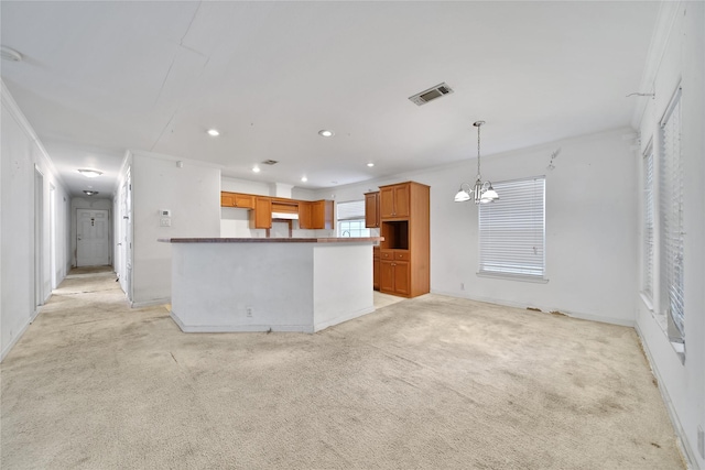 11307 Normeadow Ln, Houston, TX 77076 - kitchen with a chandelier, recessed lighting, light carpet, brown cabinets, and hanging light fixtures