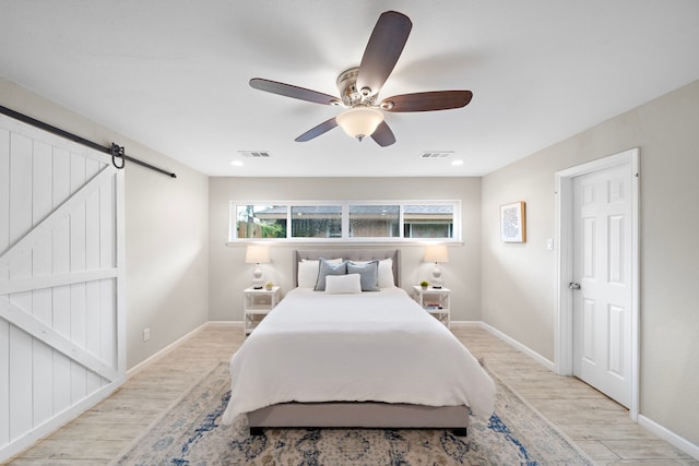 4003 Mischire Dr, Houston, TX 77025 - bedroom with light wood finished floors, a barn door, ceiling fan, and recessed lighting