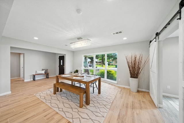 4003 Mischire Dr, Houston, TX 77025 - dining space featuring a barn door, light wood-style floors, and recessed lighting