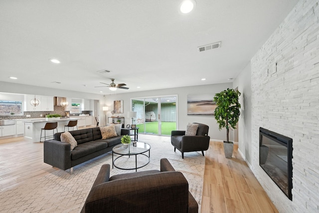 4003 Mischire Dr, Houston, TX 77025 - living area featuring light wood-style floors, a fireplace, ceiling fan, and recessed lighting