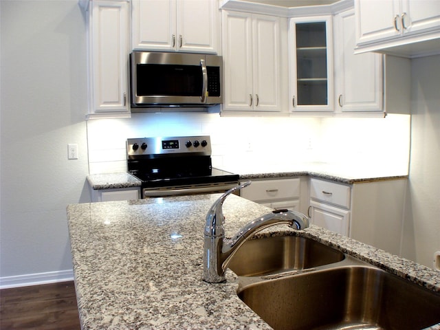 16725 Stonefield, Montgomery, TX 77316 - kitchen with appliances with stainless steel finishes, white cabinets, tasteful backsplash, light stone countertops, and glass insert cabinets