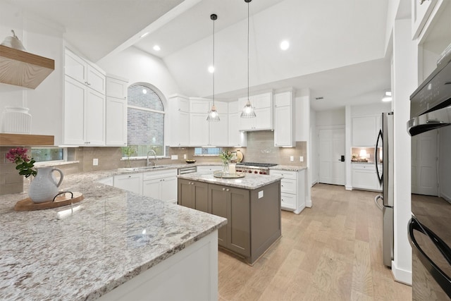 11 Forge Hill Pl, The Woodlands, TX 77381 - kitchen with light wood-type flooring, lofted ceiling, tasteful backsplash, open shelves, and white cabinetry