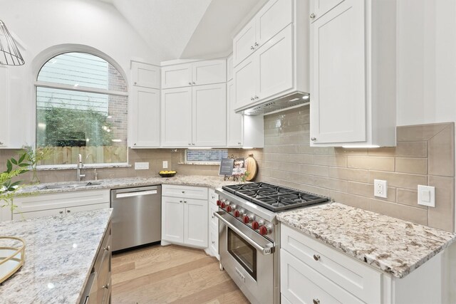 11 Forge Hill Pl, The Woodlands, TX 77381 - kitchen with appliances with stainless steel finishes, lofted ceiling, light wood-style flooring, white cabinets, and backsplash
