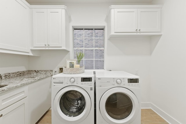 11 Forge Hill Pl, The Woodlands, TX 77381 - laundry area featuring independent washer and dryer, cabinet space, and light tile patterned floors