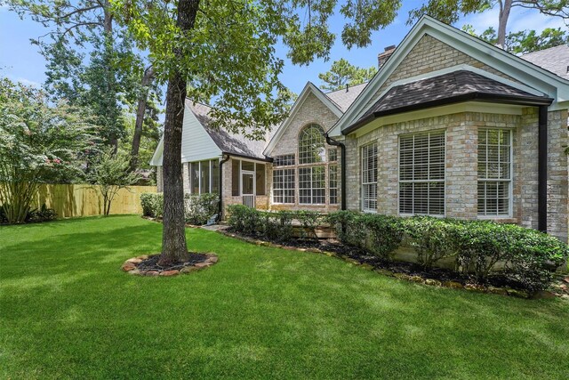 11 Forge Hill Pl, The Woodlands, TX 77381 - view of property exterior featuring a chimney, a sunroom, stone siding, and roof with shingles