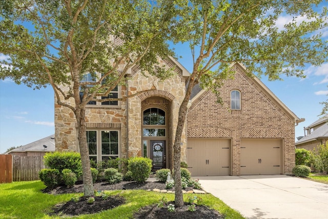 28842 Thornbird Ct, Katy, TX 77494 - view of front of house featuring driveway, stone siding, brick siding, and a garage