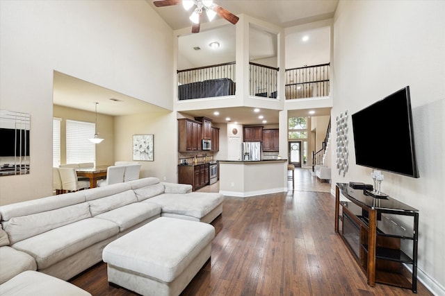 28842 Thornbird Ct, Katy, TX 77494 - living area with ceiling fan, dark wood finished floors, stairs, and a towering ceiling