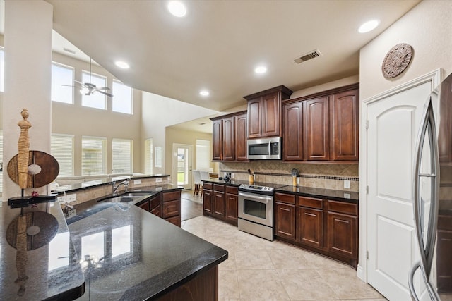28842 Thornbird Ct, Katy, TX 77494 - kitchen with appliances with stainless steel finishes, a ceiling fan, backsplash, recessed lighting, and dark brown cabinets