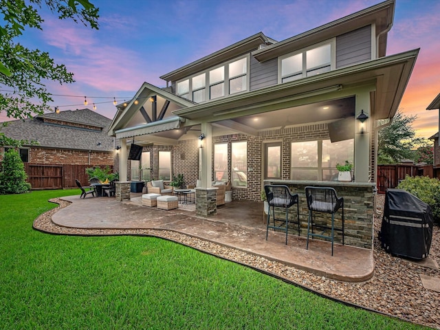 10515 Trinity Springs Dr, Cypress, TX 77433 - back of house at dusk with a patio and brick siding
