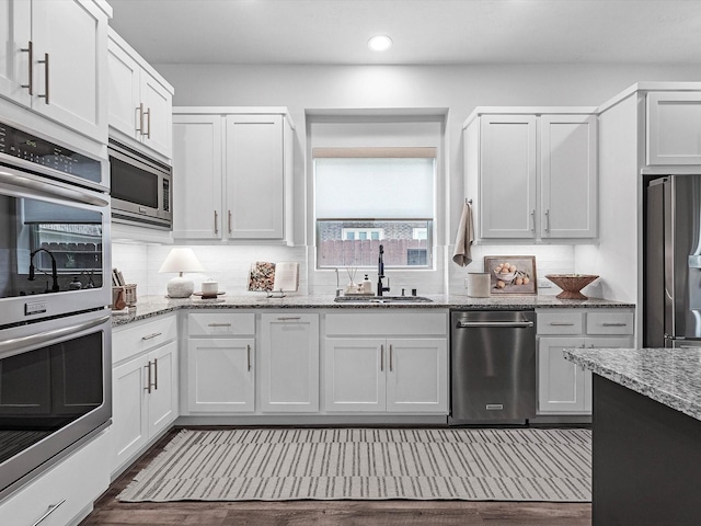 10515 Trinity Springs Dr, Cypress, TX 77433 - kitchen featuring appliances with stainless steel finishes, recessed lighting, light stone countertops, decorative backsplash, and dark wood-style floors