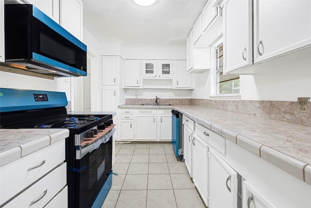 12434 Kathryn St, Houston, TX 77015 - kitchen with stainless steel gas range, white cabinets, light tile patterned floors, and dishwashing machine