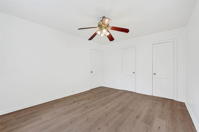 12434 Kathryn St, Houston, TX 77015 - unfurnished bedroom with light wood-style flooring, ceiling fan, and two closets