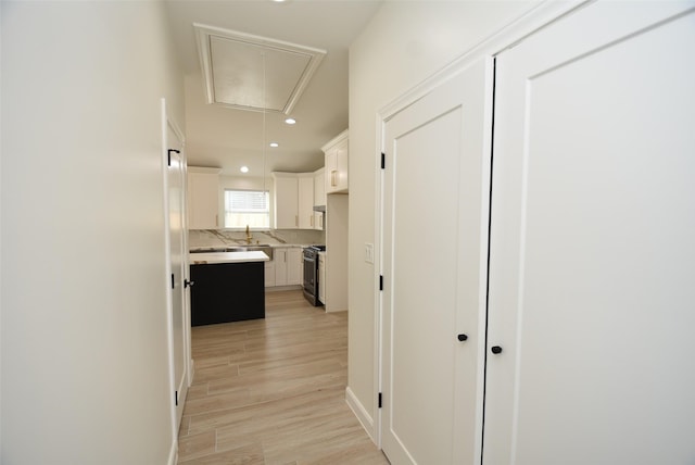 729 Caperton St, Houston, TX 77022 - corridor featuring attic access, light wood-style flooring, and recessed lighting