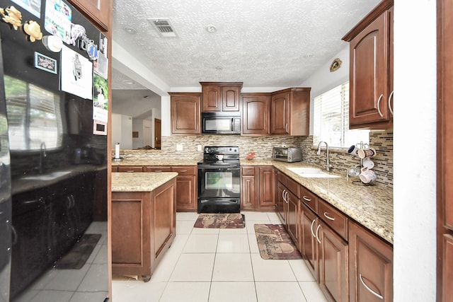 13411 Natasha Ln, Houston, TX 77015 - kitchen with black appliances, tasteful backsplash, light tile patterned floors, a textured ceiling, and light stone countertops
