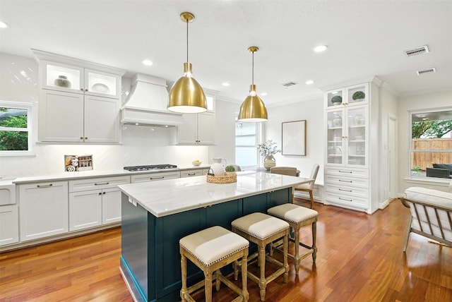 1211 Villmont Ln, Houston, TX 77077 - kitchen with premium range hood, white cabinetry, plenty of natural light, wood finished floors, and recessed lighting