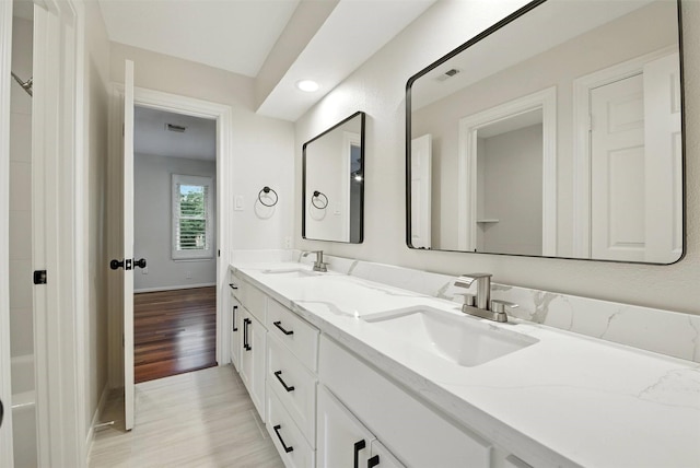 1211 Villmont Ln, Houston, TX 77077 - bathroom with double vanity, wood finished floors, and recessed lighting