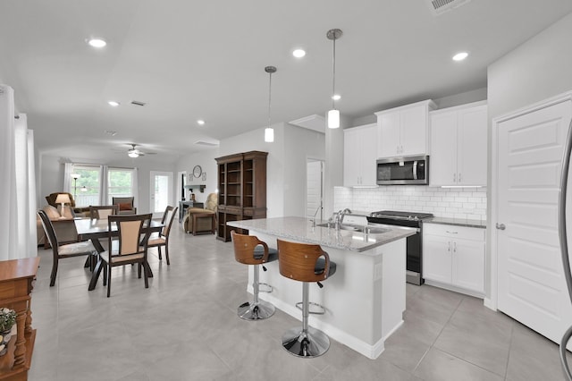18529 Meadow Point Ln, Montgomery, TX 77316 - kitchen with stainless steel appliances, tasteful backsplash, light stone counters, white cabinetry, and recessed lighting