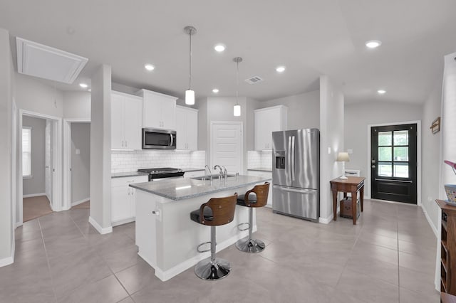 18529 Meadow Point Ln, Montgomery, TX 77316 - kitchen with stainless steel appliances, decorative backsplash, a center island with sink, white cabinetry, and recessed lighting