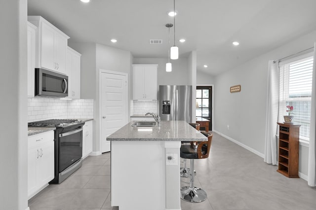 18529 Meadow Point Ln, Montgomery, TX 77316 - kitchen featuring appliances with stainless steel finishes, light stone counters, a kitchen island with sink, decorative backsplash, and recessed lighting