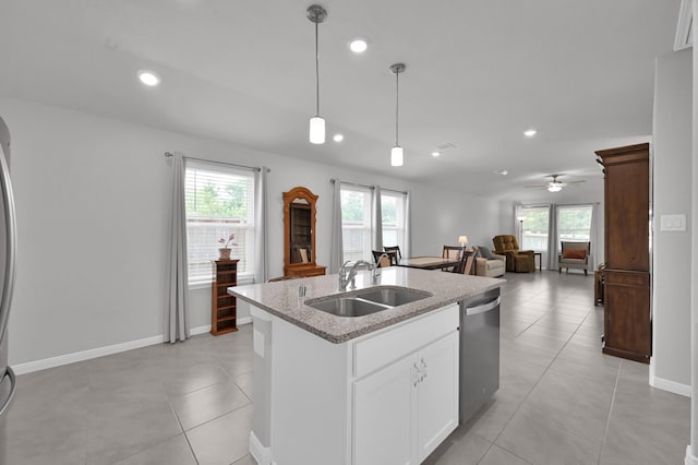 18529 Meadow Point Ln, Montgomery, TX 77316 - kitchen featuring stainless steel dishwasher, a center island with sink, decorative light fixtures, light stone counters, and light tile patterned flooring