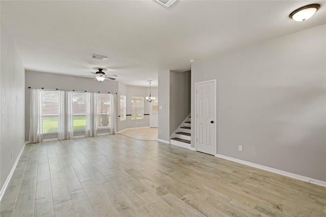 12106 Hawthorne Hill Cir, Humble, TX 77346 - spare room featuring a ceiling fan, a chandelier, stairway, and light wood-style flooring