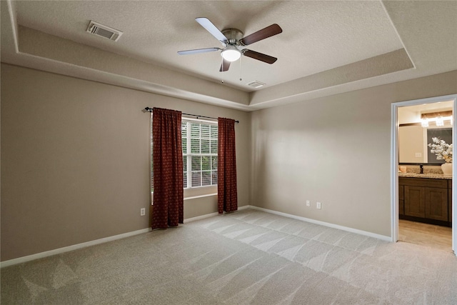 12106 Hawthorne Hill Cir, Humble, TX 77346 - spare room featuring light colored carpet, a textured ceiling, a raised ceiling, and ceiling fan