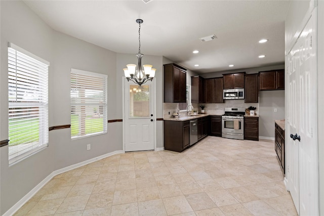 12106 Hawthorne Hill Cir, Humble, TX 77346 - kitchen featuring stainless steel appliances, a chandelier, dark brown cabinets, backsplash, and pendant lighting