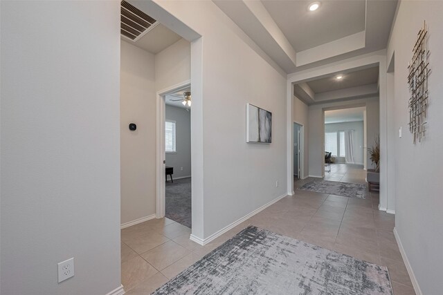 25446 Fossa Dr, Tomball, TX 77375 - corridor featuring tile patterned flooring and a tray ceiling