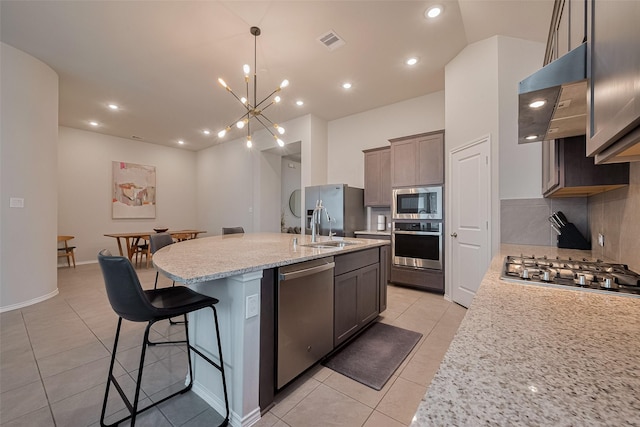 25446 Fossa Dr, Tomball, TX 77375 - kitchen featuring stainless steel appliances, ventilation hood, light tile patterned flooring, a kitchen bar, and a center island with sink