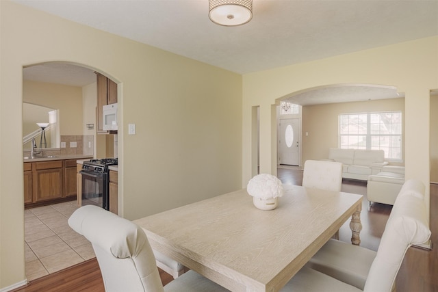 18107 Mayfield Meadow Ln, Richmond, TX 77407 - dining space with arched walkways and light wood-style flooring