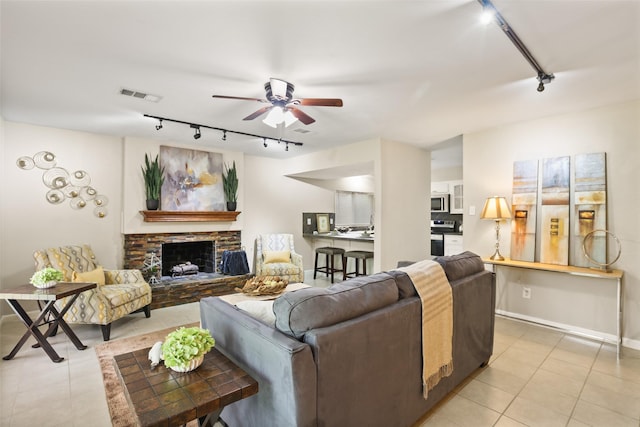 2151 Middle Creek Dr, Houston, TX 77339 - living area featuring track lighting, a ceiling fan, a fireplace with raised hearth, and light tile patterned flooring