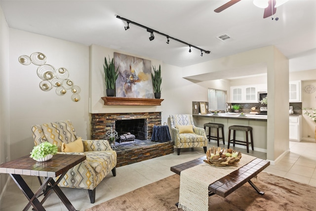 2151 Middle Creek Dr, Houston, TX 77339 - living area with track lighting, light tile patterned floors, a ceiling fan, and a stone fireplace