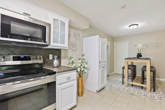 2151 Middle Creek Dr, Houston, TX 77339 - kitchen featuring stainless steel appliances, backsplash, white cabinetry, and glass insert cabinets