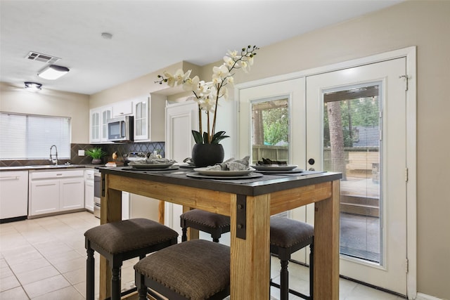 2151 Middle Creek Dr, Houston, TX 77339 - kitchen featuring range with electric cooktop, stainless steel microwave, white dishwasher, light tile patterned flooring, and white cabinetry