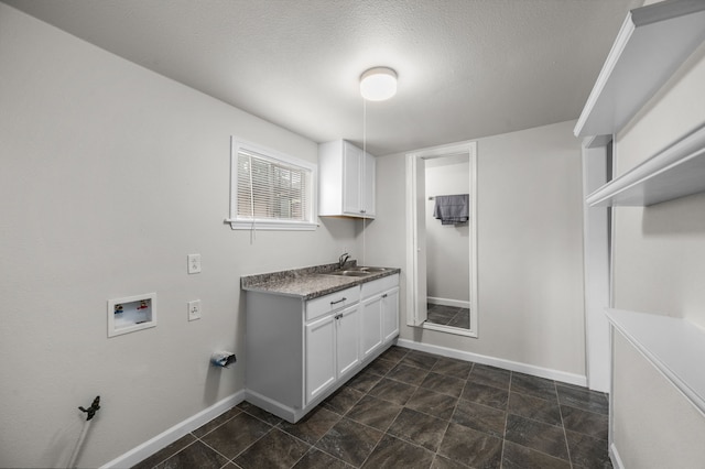 5519 Chapman St, Houston, TX 77009 - laundry room featuring hookup for a washing machine, cabinet space, and a textured ceiling