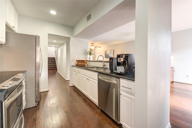 1964 Augusta Dr, Houston, TX 77057 - kitchen featuring appliances with stainless steel finishes, dark countertops, dark wood-style floors, white cabinets, and ceiling fan