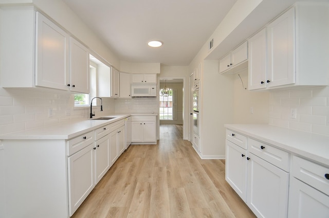 10623 Longmont Dr, Houston, TX 77042 - kitchen with white appliances, healthy amount of natural light, white cabinetry, and recessed lighting