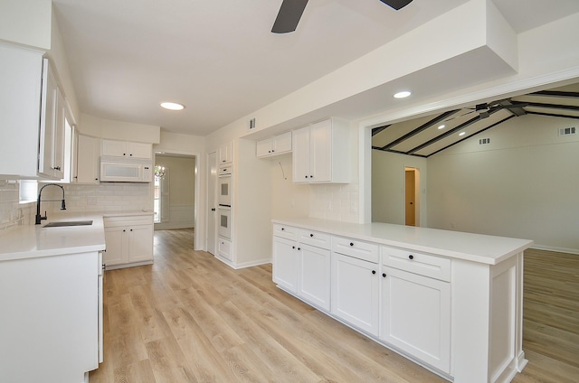 10623 Longmont Dr, Houston, TX 77042 - kitchen with a ceiling fan, white appliances, white cabinetry, and recessed lighting