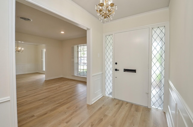 10623 Longmont Dr, Houston, TX 77042 - entrance foyer featuring a chandelier, a decorative wall, light wood-style floors, wainscoting, and ornamental molding