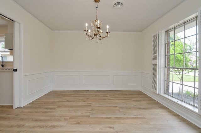 10623 Longmont Dr, Houston, TX 77042 - empty room featuring a chandelier, ornamental molding, a wainscoted wall, light wood-style flooring, and a decorative wall