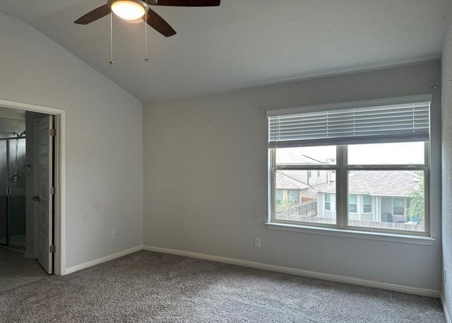 12906 Awuzie Trl, San Antonio, TX 78254 - unfurnished bedroom featuring light colored carpet, vaulted ceiling, a ceiling fan, and ensuite bath