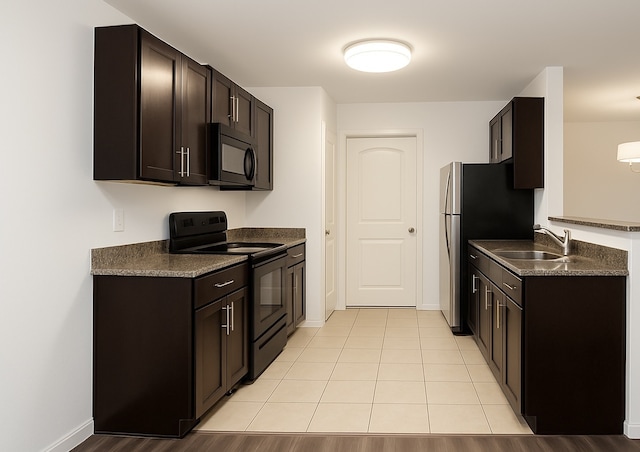 13406 Pine Tree Forest Trl, Houston, TX 77049 - kitchen with black appliances, dark countertops, and dark brown cabinetry