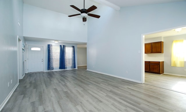 22635 River Birch Dr, Tomball, TX 77375 - unfurnished living room featuring high vaulted ceiling, ceiling fan, light wood-style floors, and beam ceiling
