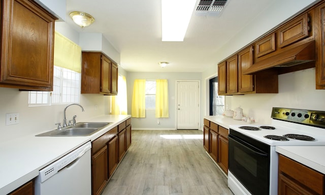 22635 River Birch Dr, Tomball, TX 77375 - kitchen with range with electric cooktop, white dishwasher, light countertops, light wood-style floors, and brown cabinets