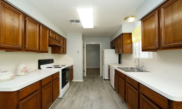 22635 River Birch Dr, Tomball, TX 77375 - kitchen with white appliances, light wood-type flooring, light countertops, and brown cabinetry