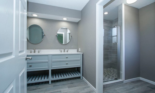 22635 River Birch Dr, Tomball, TX 77375 - full bathroom with double vanity, a shower stall, wood finished floors, and recessed lighting