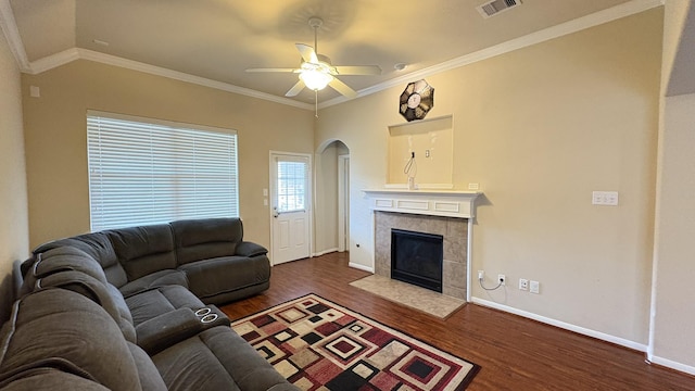 20530 Keegans Ledge Ln, Cypress, TX 77433 - living area featuring dark wood-style flooring, a ceiling fan, arched walkways, a fireplace, and ornamental molding
