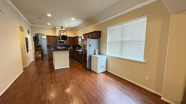 20530 Keegans Ledge Ln, Cypress, TX 77433 - kitchen with stainless steel appliances, arched walkways, a kitchen island, dark wood-type flooring, and crown molding